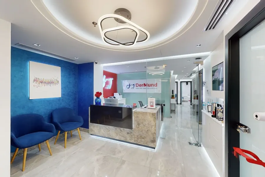 DerMund reception with navy seating, red accents and the clinic logo